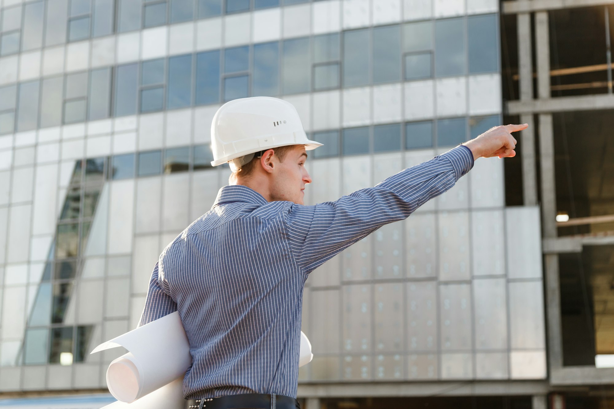 architect with drawings indicating the plug on the facade of the building.